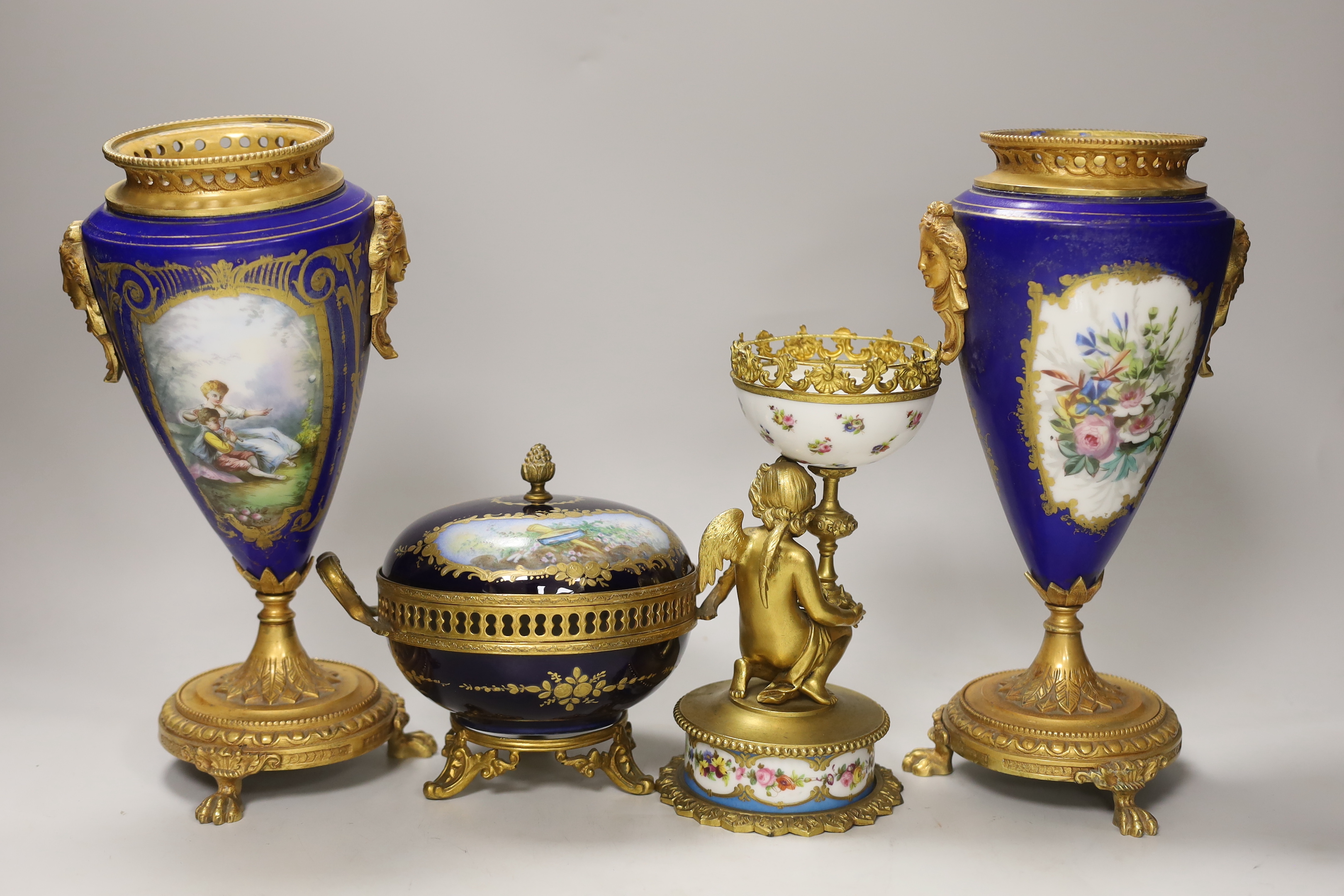 A pair of Sevres style porcelain ormolu mounted vases, a similar putti stemmed cup and a bowl and cover, tallest 27cm